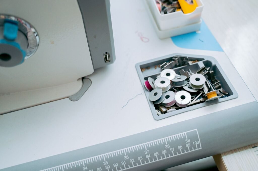 Caja de canillas y accesorios sobre la mesa de una máquina de coser
